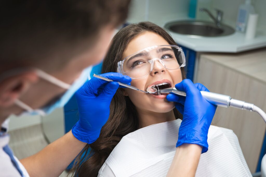 Woman with brown hair undergoing root canal looking at dentist